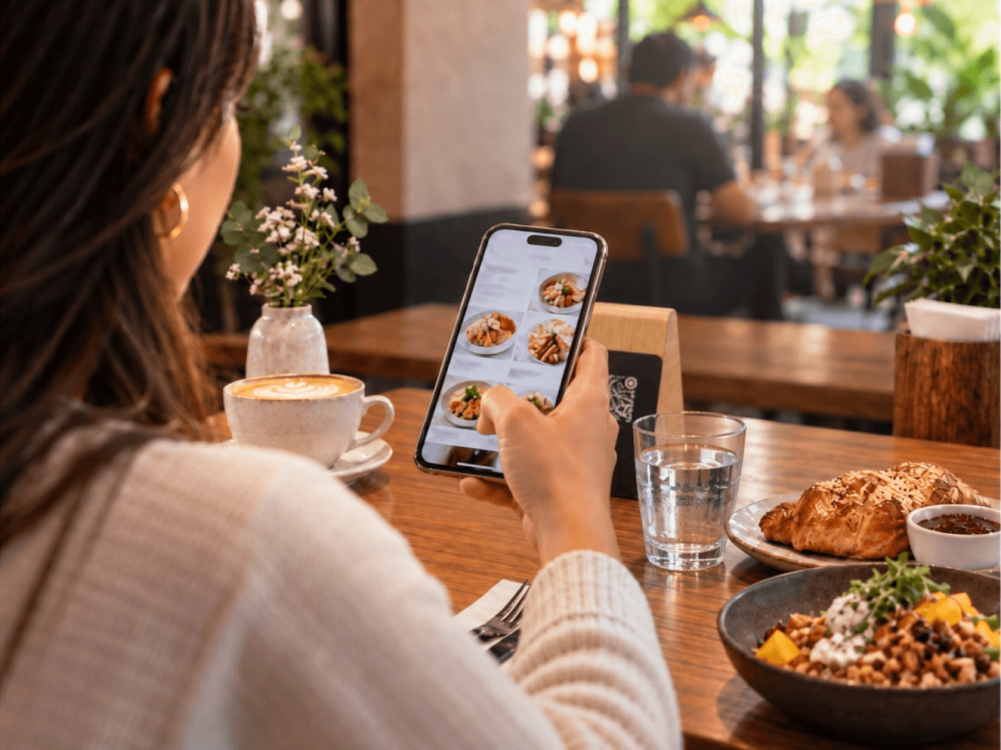 Una Portta sobre una mesa conecta la experiencia física del negocio con una Cartta abierta en un celular.